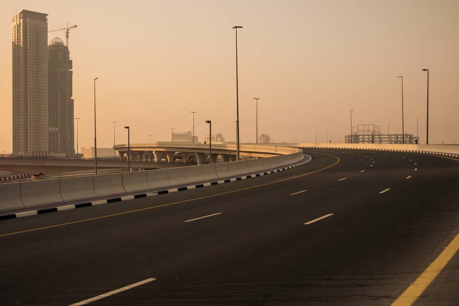 The morning sun takes a peek around the highrises on Sheikh Zayed Rd (E11 Highway)