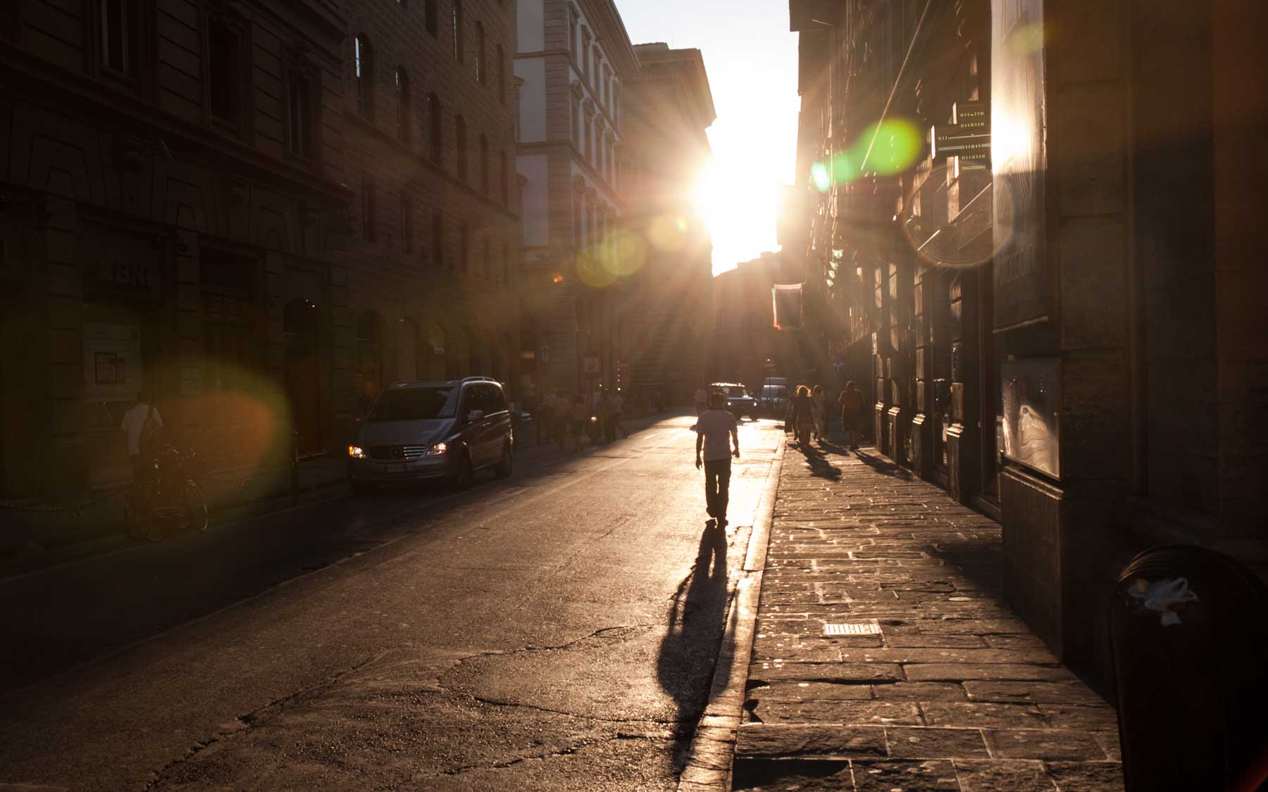 The evening sun stretches down the Via degli Strozzi.